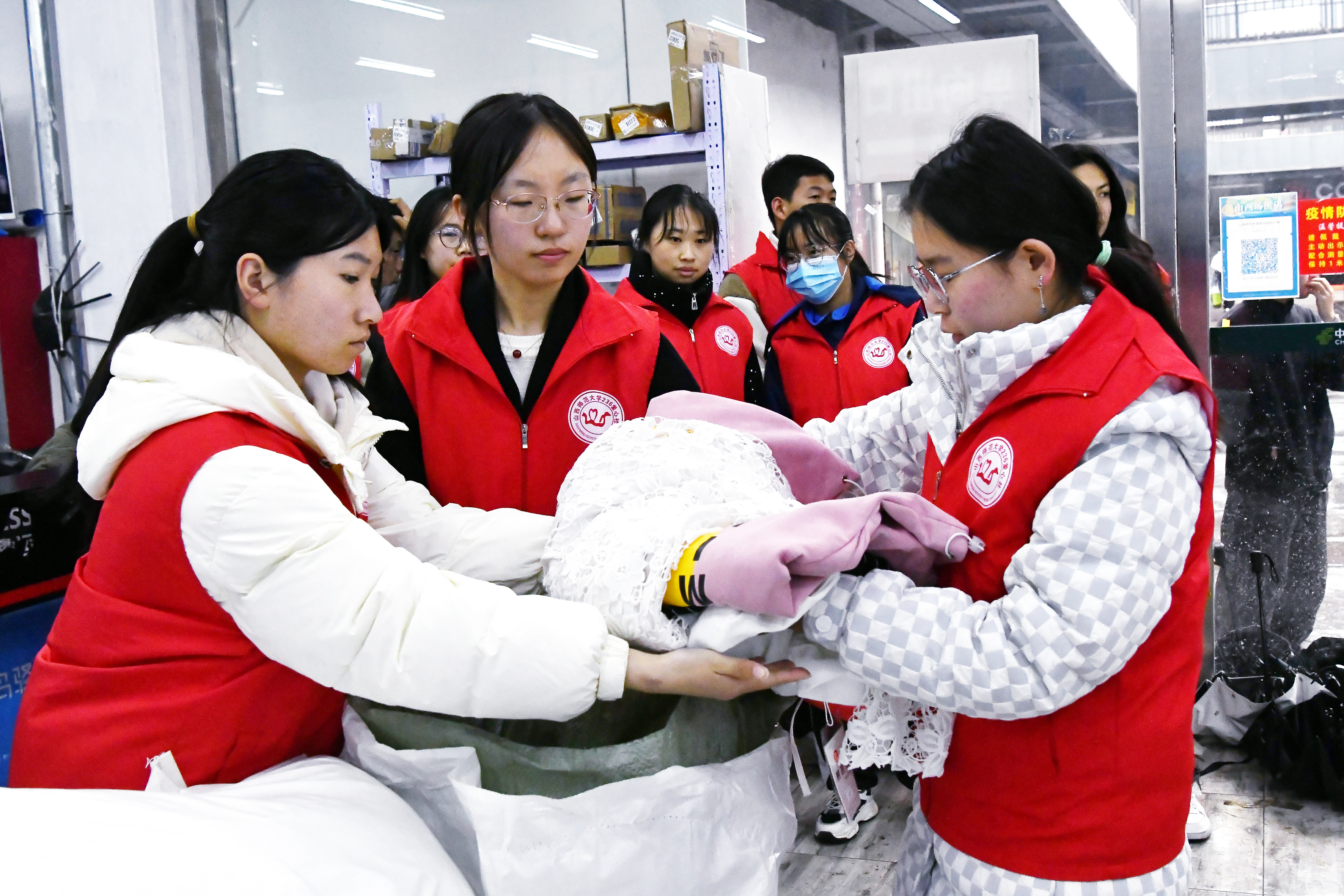 4月23日，在“世界读书日”当天，山西师范大学“236爱心社”部分青年志愿者在学子广场菜鸟驿站开展“奉献爱心 传递温情”活动，几名志愿者把整理衣物放到衣物袋 史芷欣 摄.JPG