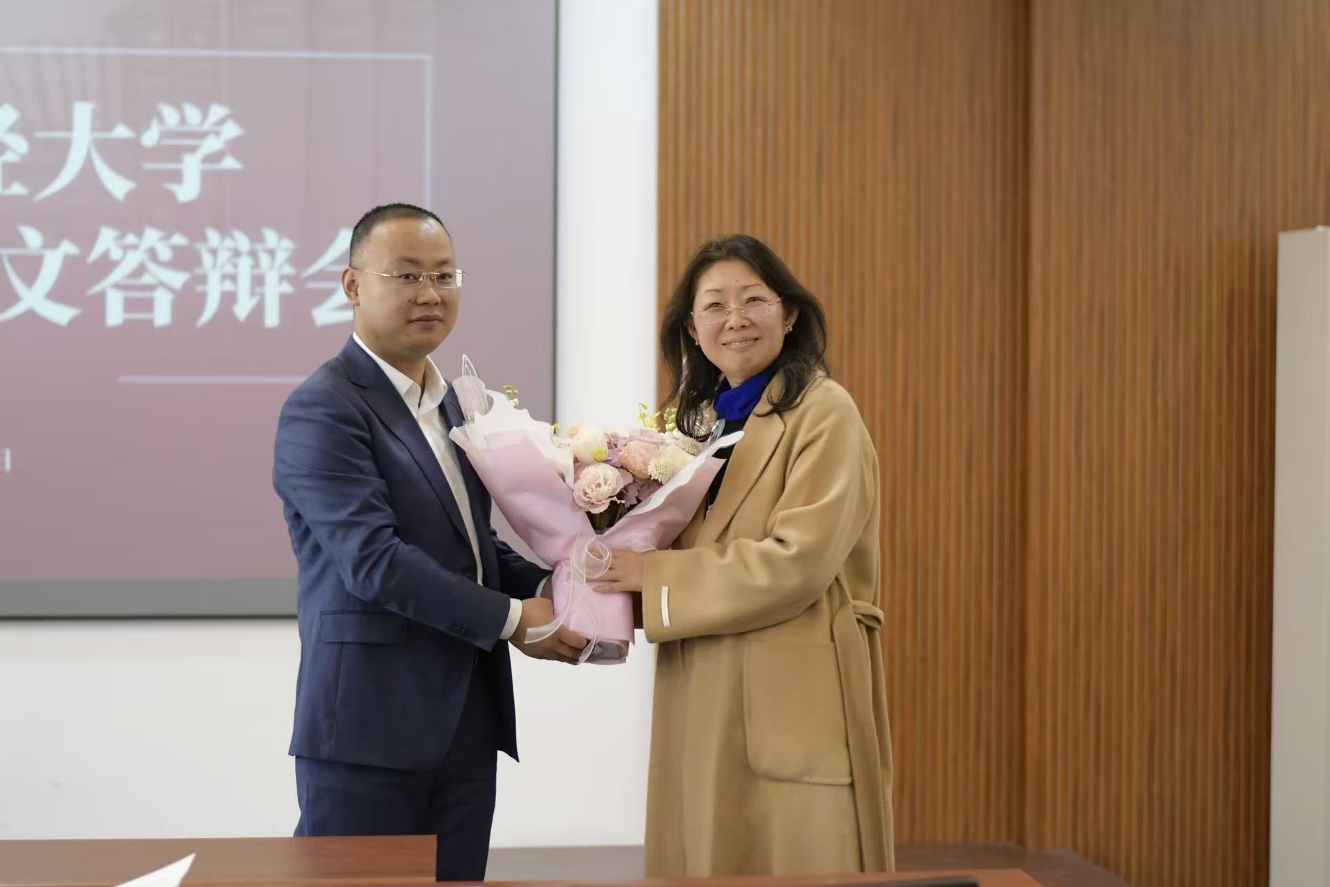 4.吴晓在博士学位论文答辩会后向导师丁宁教授献花.jpg