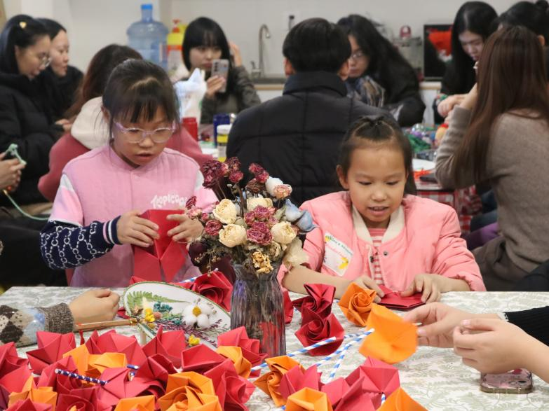 学生成员带领社区小朋友进行纸玫瑰花折叠 学生成员带领社区小朋友进行纸玫瑰花折叠