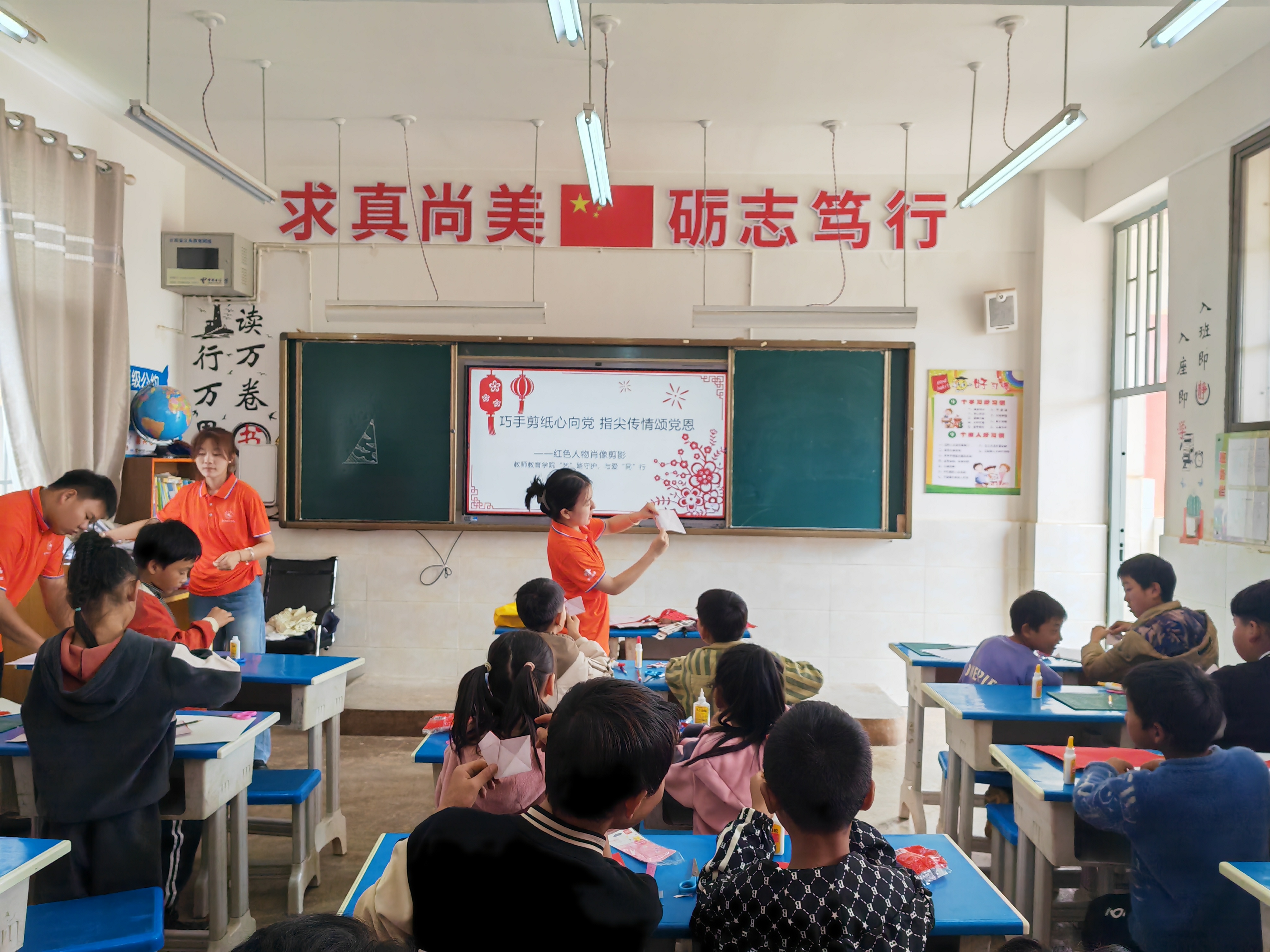 志愿者组织野猪村小学留守儿童开展“巧手剪纸心向党,指尖传情颂党恩”彩色剪纸活动