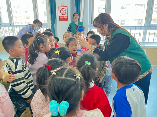 志愿者向小朋友展示柱式净水装置