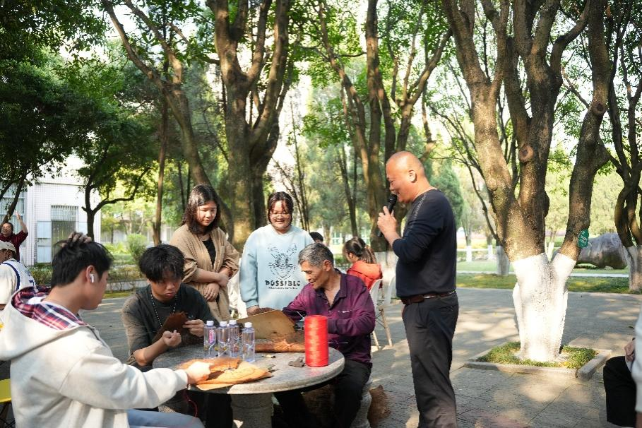 图为老师讲授蓑衣制作方法。
