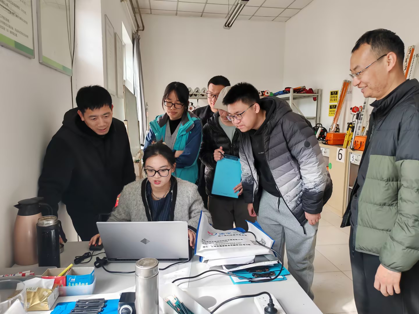 企业技术人员为师生团队讲解第五代智能测绘装备的使用方法