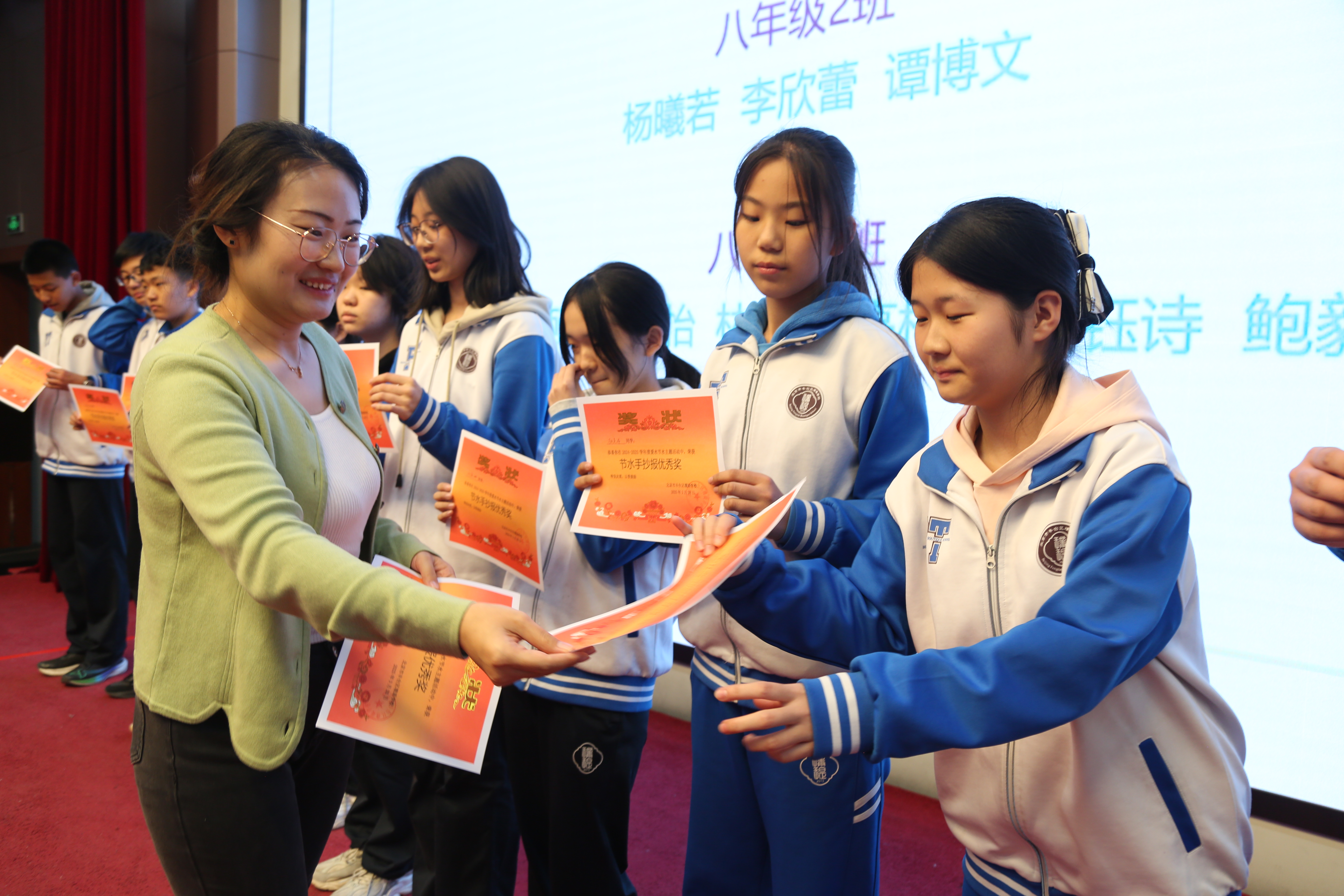 冯吉老师为在节水主题手抄报活动中获奖同学进行颁奖