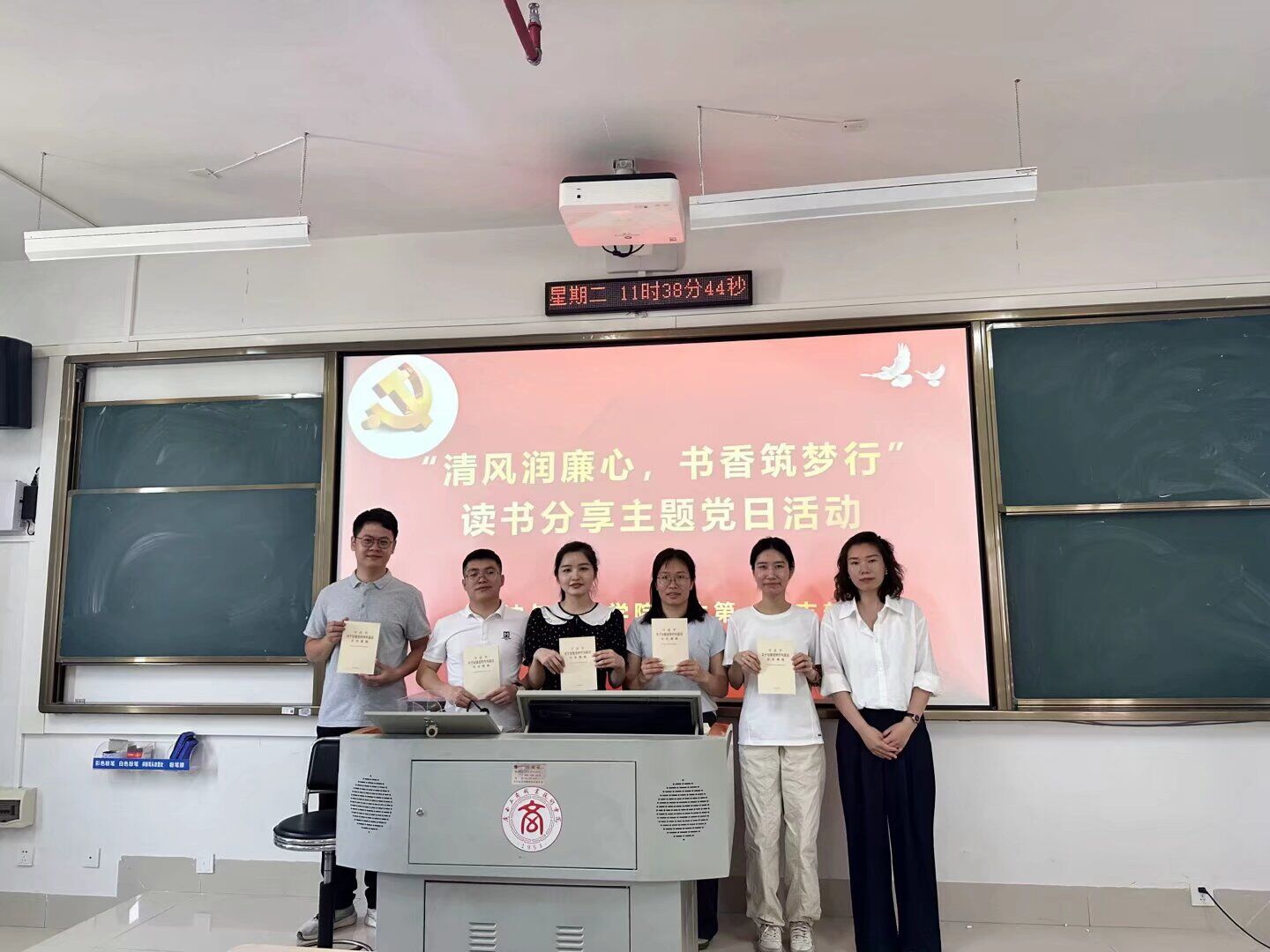 图为 支部书记常荣荣给党员赠送书籍