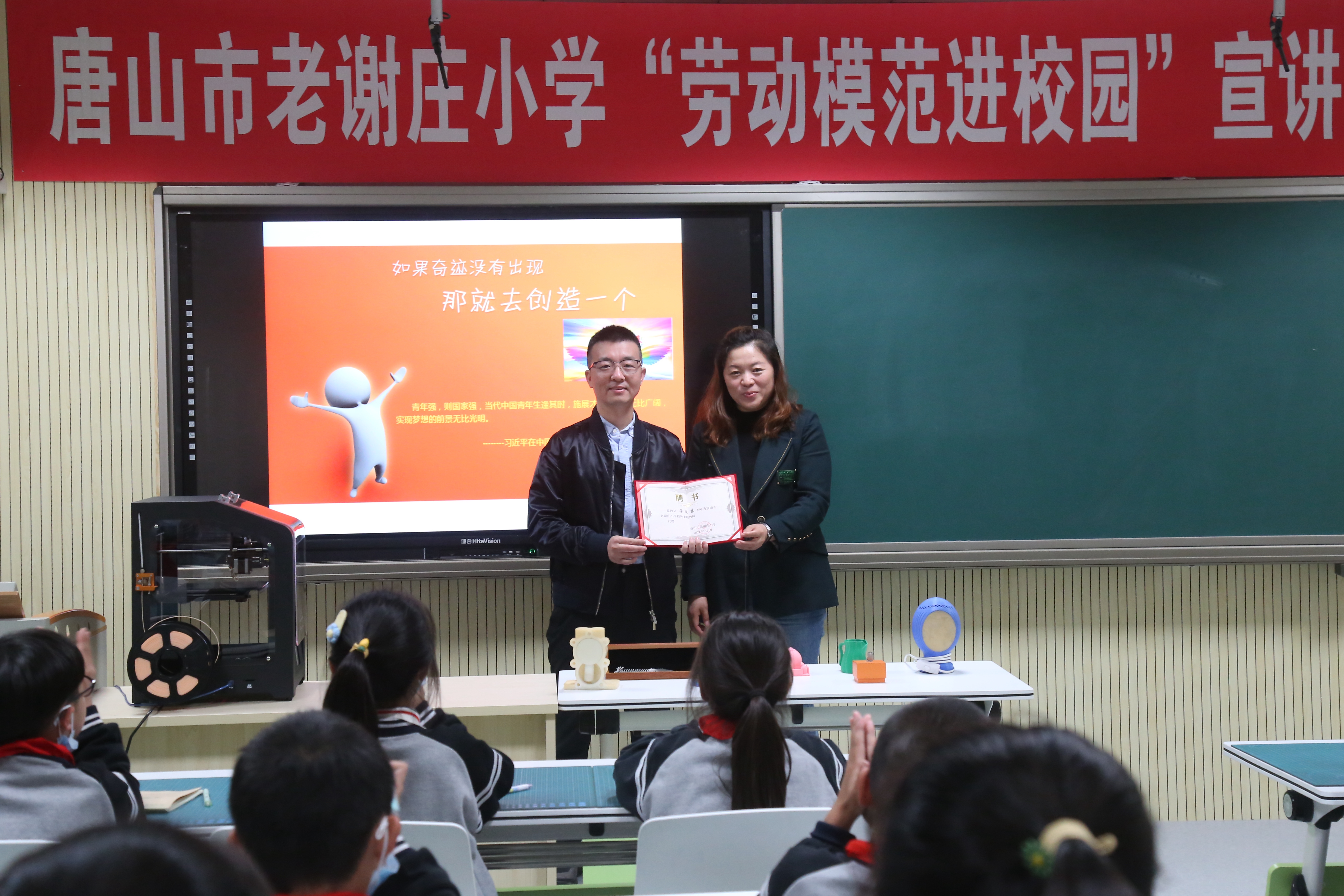 图5 党员教师薄向东（左）赴唐山市老谢庄小学开展“劳动模范进校园”宣讲活动