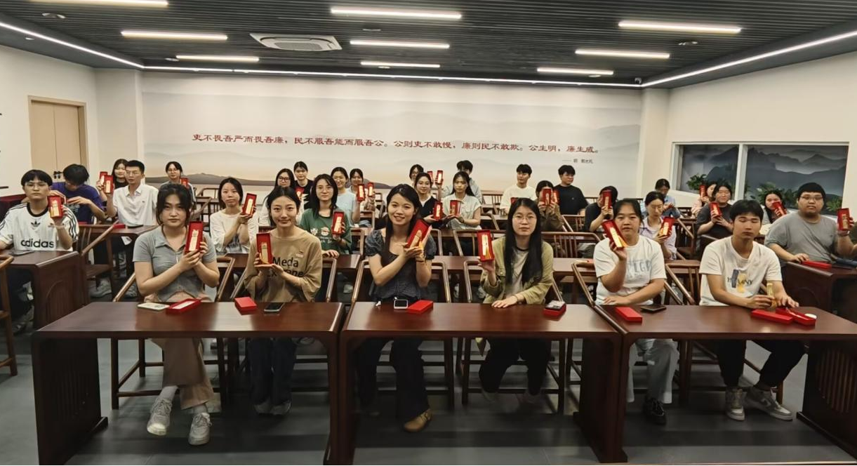 图为毕业生党员展示廉洁纪念品