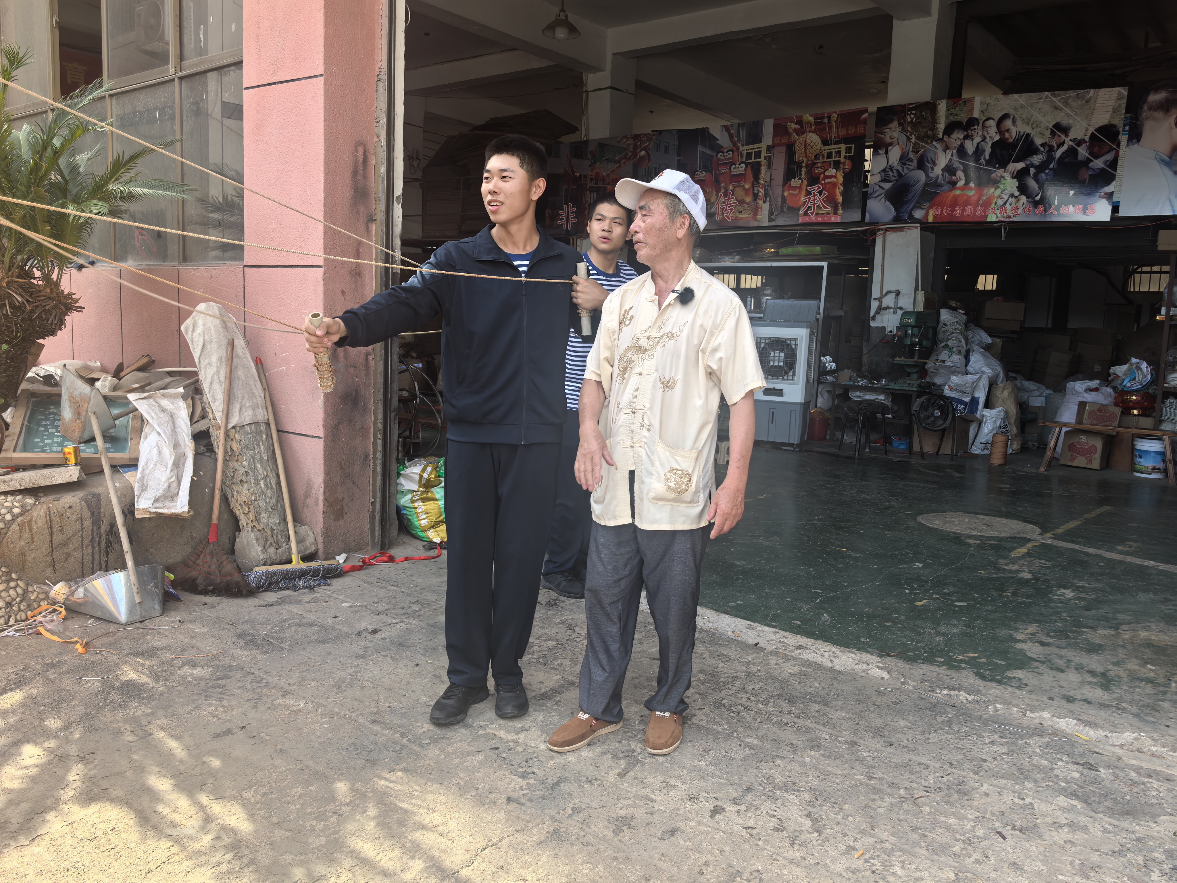 图为实践团成员在传承人的指导下沉浸式舞动九狮图