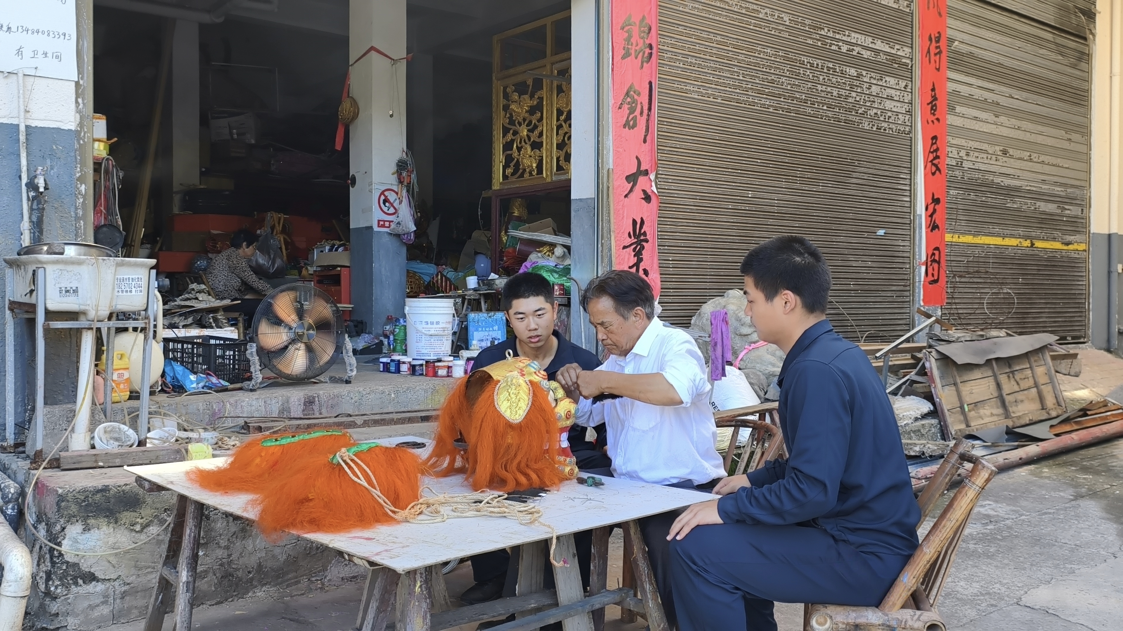 图为实践团成员认真聆听胡师傅讲解九狮图制作技艺