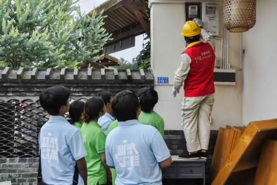 图为同学们观看工作人员电表实操 图为同学们观看工作人员电表实操