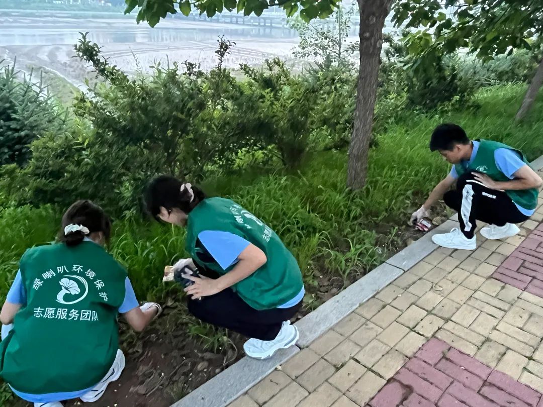 团队成员捡拾河道岸边垃圾