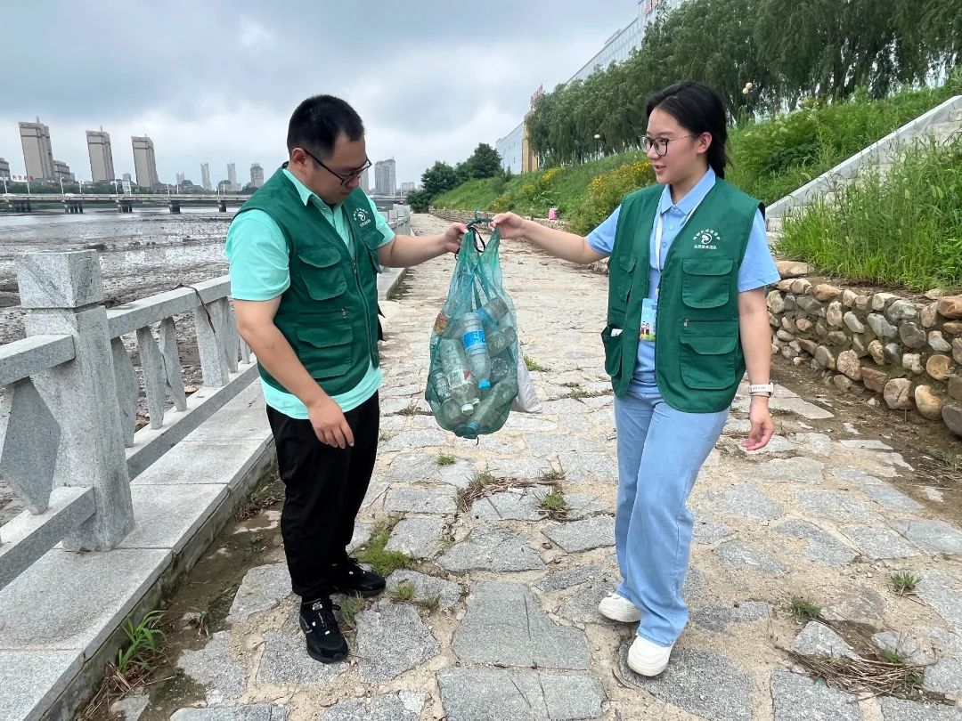 团队成员打捞河边塑料瓶