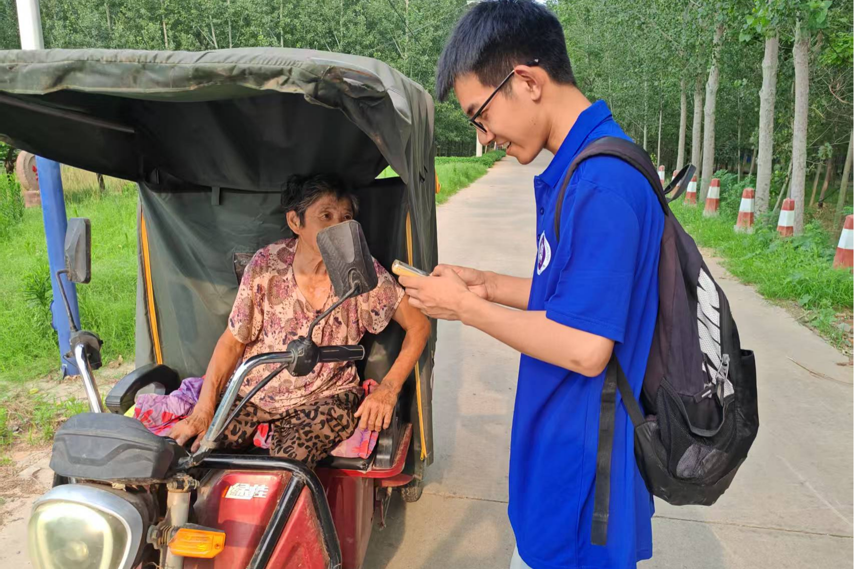 实践团队成员教老人使用手机。 任子聪 供图 实践团队成员教老人使用手机。 任子聪 供图