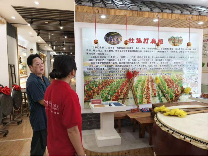 文化馆唐老师为实践团成员讲解壮族打扁担