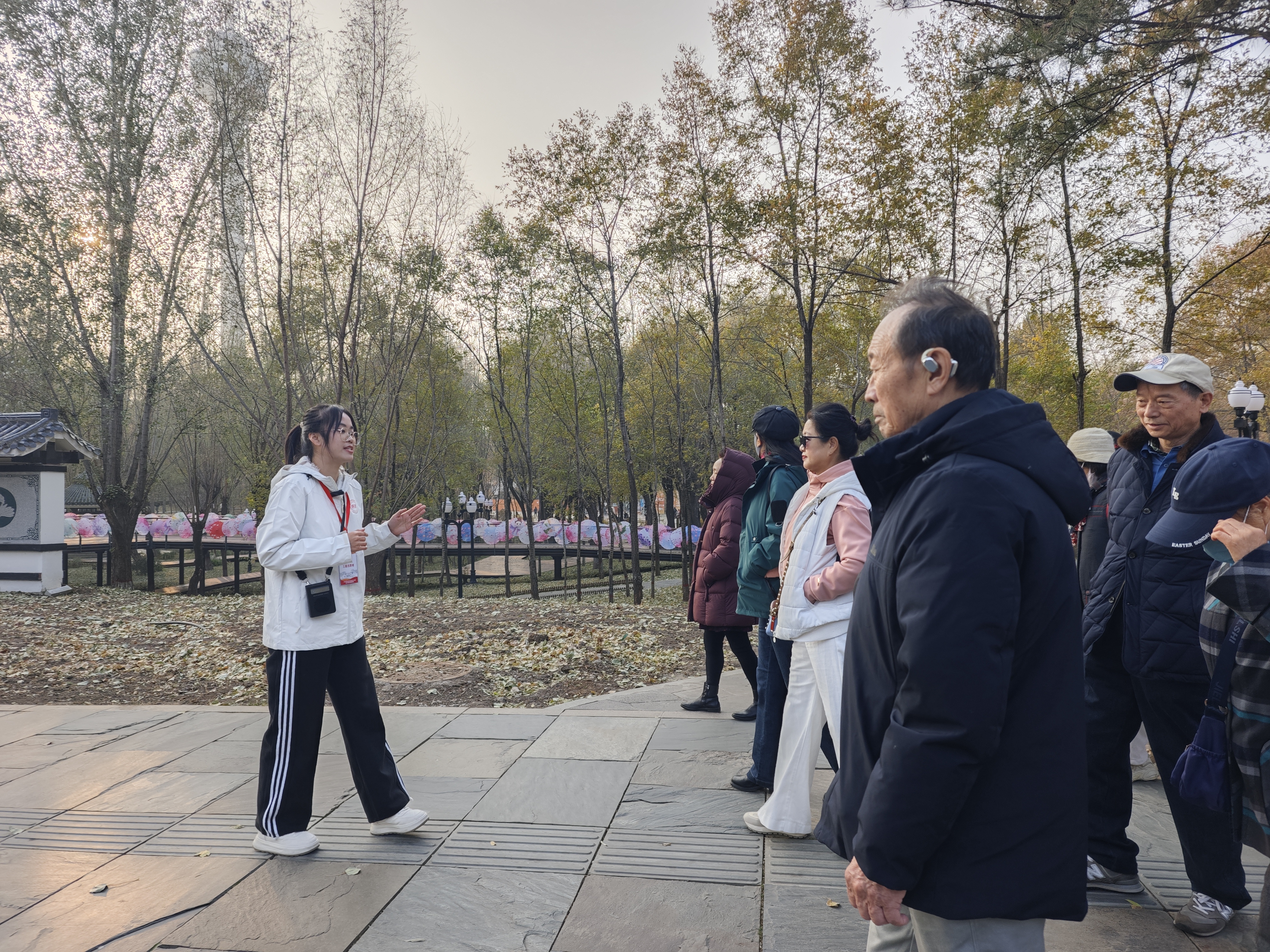 【3】图三:2025年11月12日,东北师范大学马克思主义学部党委与学校离退休工作处党委共同开展讲解新民大街历史志愿服务活动,学生志愿者张文硕为离退休教师讲解吉林广播电视塔和朝阳公园。(宋冰供图) 【3】图三:2025年11月12日,东北师范大学马克思主义学部党委与学校离退休工作处党委共同开展讲解新民大街历史志愿服务活动,学生志愿者张文硕为离退休教师讲解吉林广播电视塔和朝阳公园。(宋冰供图)