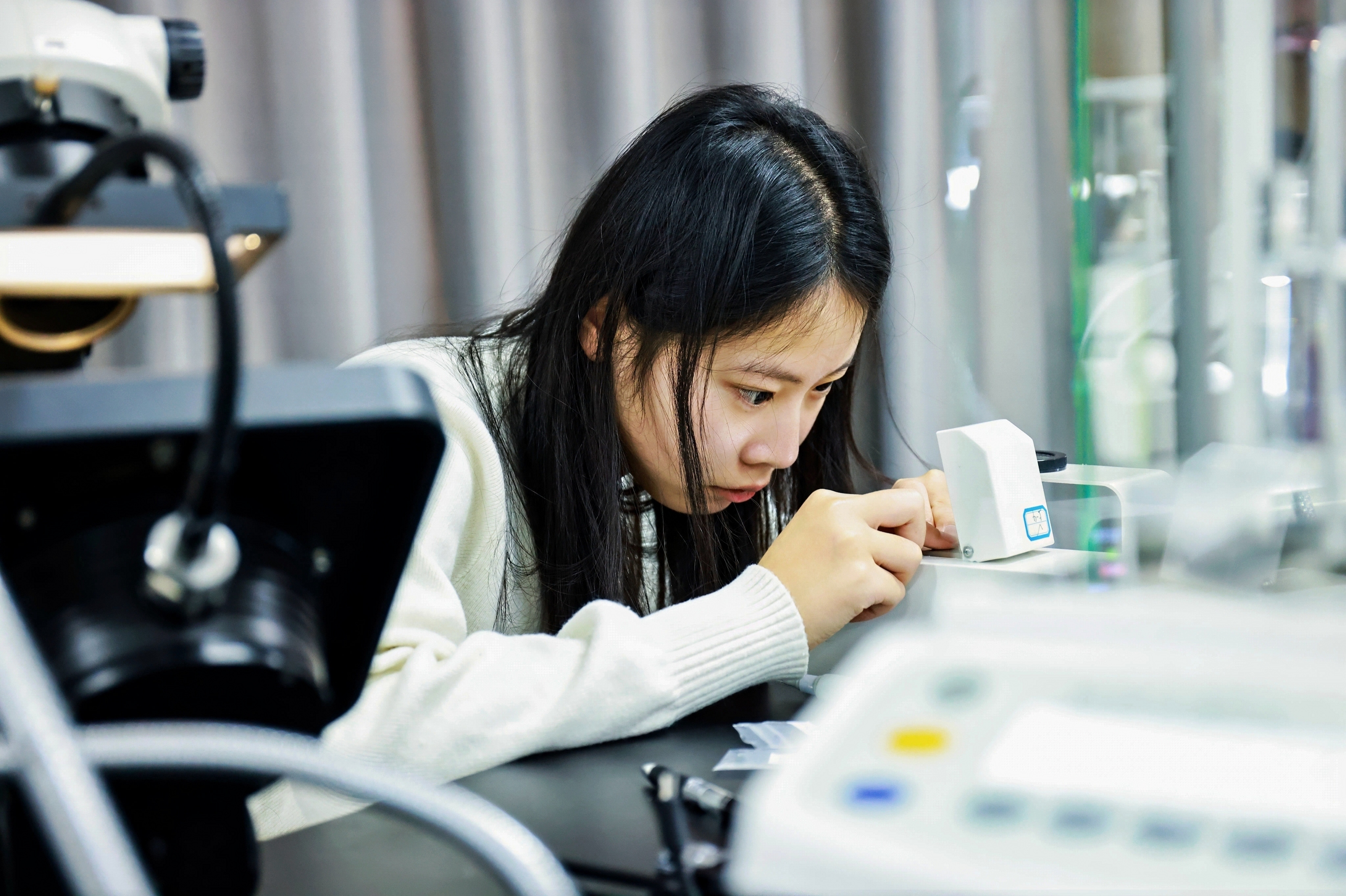 选手在比赛中（利用折射仪测定宝石折射率）