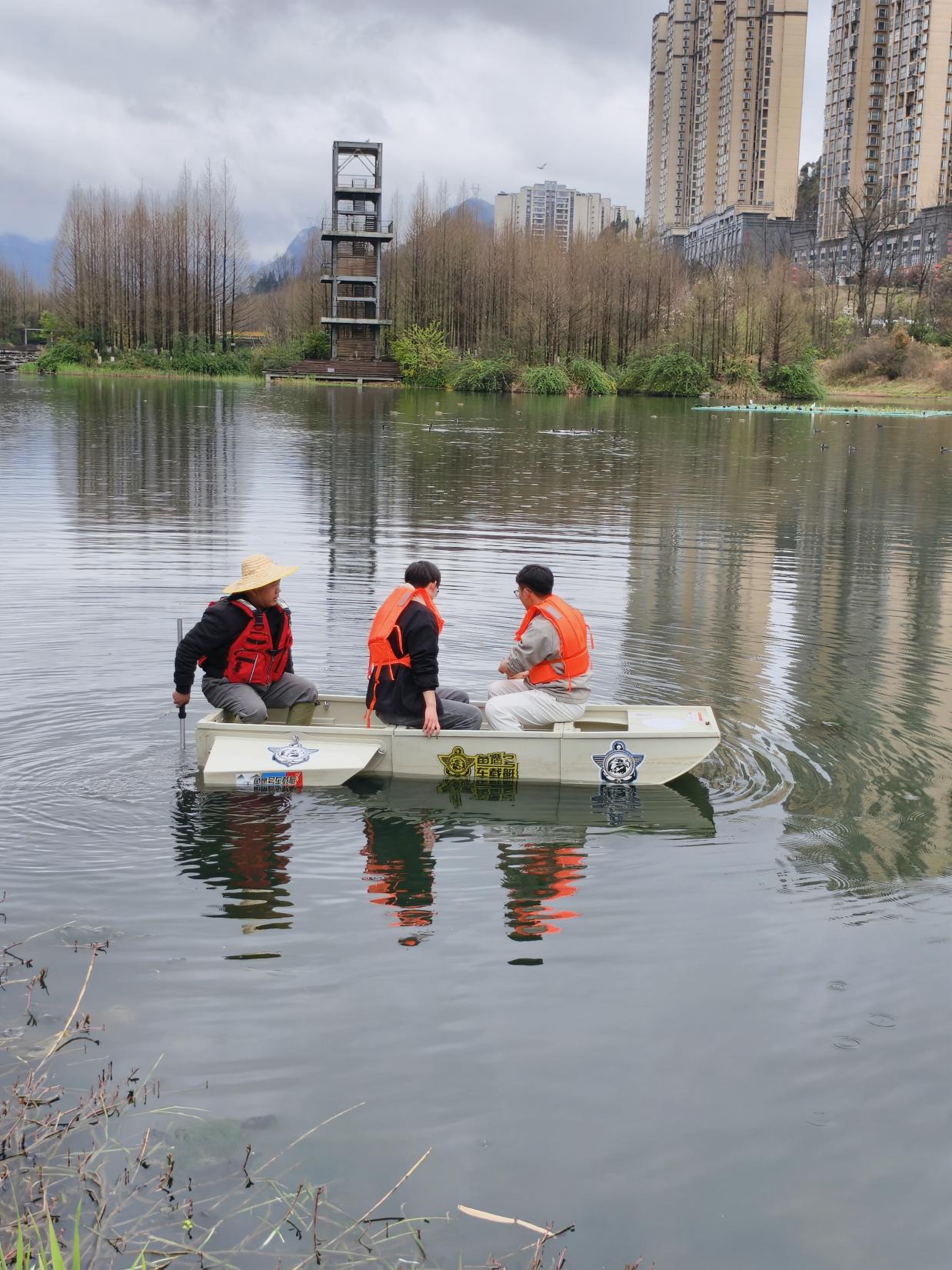 图为肖波老师和学生开展水上荷花定植作业