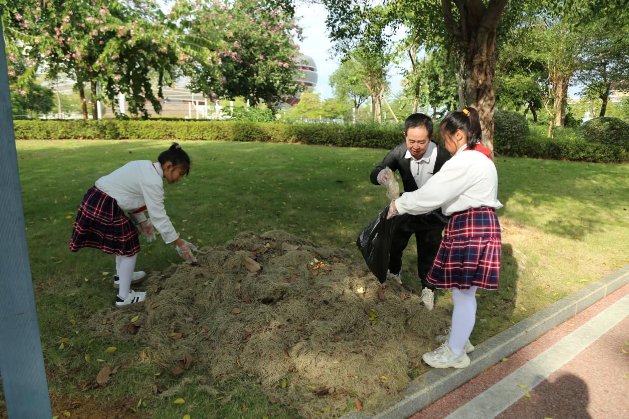 教师党员与小学生协作收拾垃圾.jpg