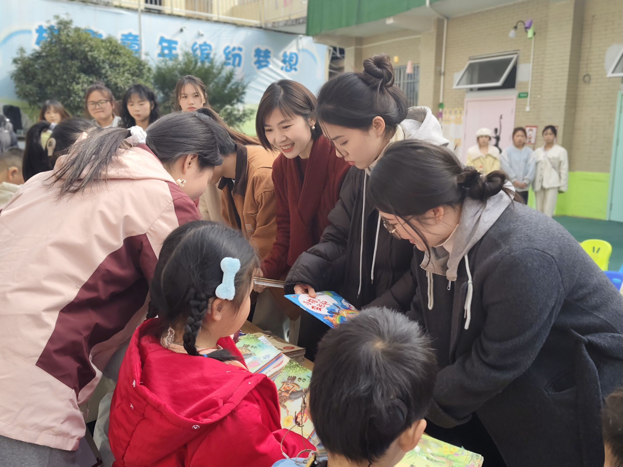 贵州师范学院美术与设计学院师生把捐赠绘本送到小朋友手中.jpg