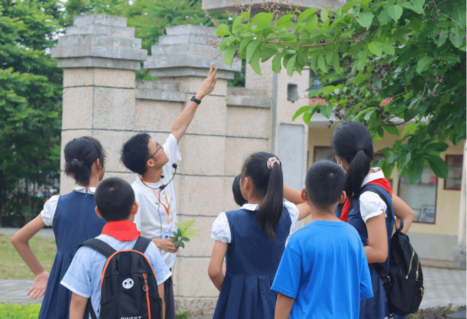 讲解员认真介绍校园植物.png