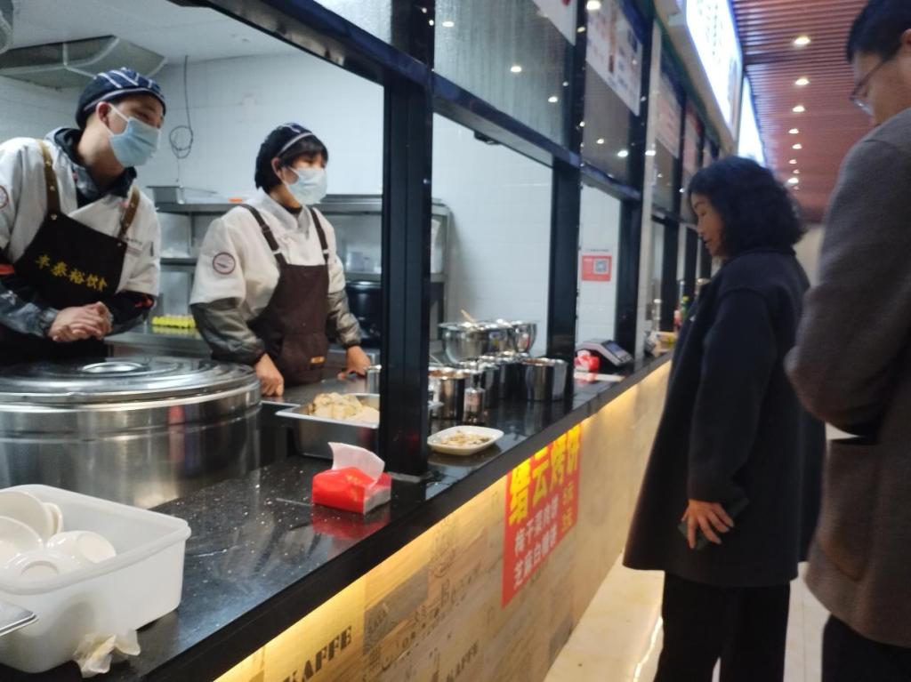 安顺学院校长曾丽与惜辛园食堂工作人员交谈.png