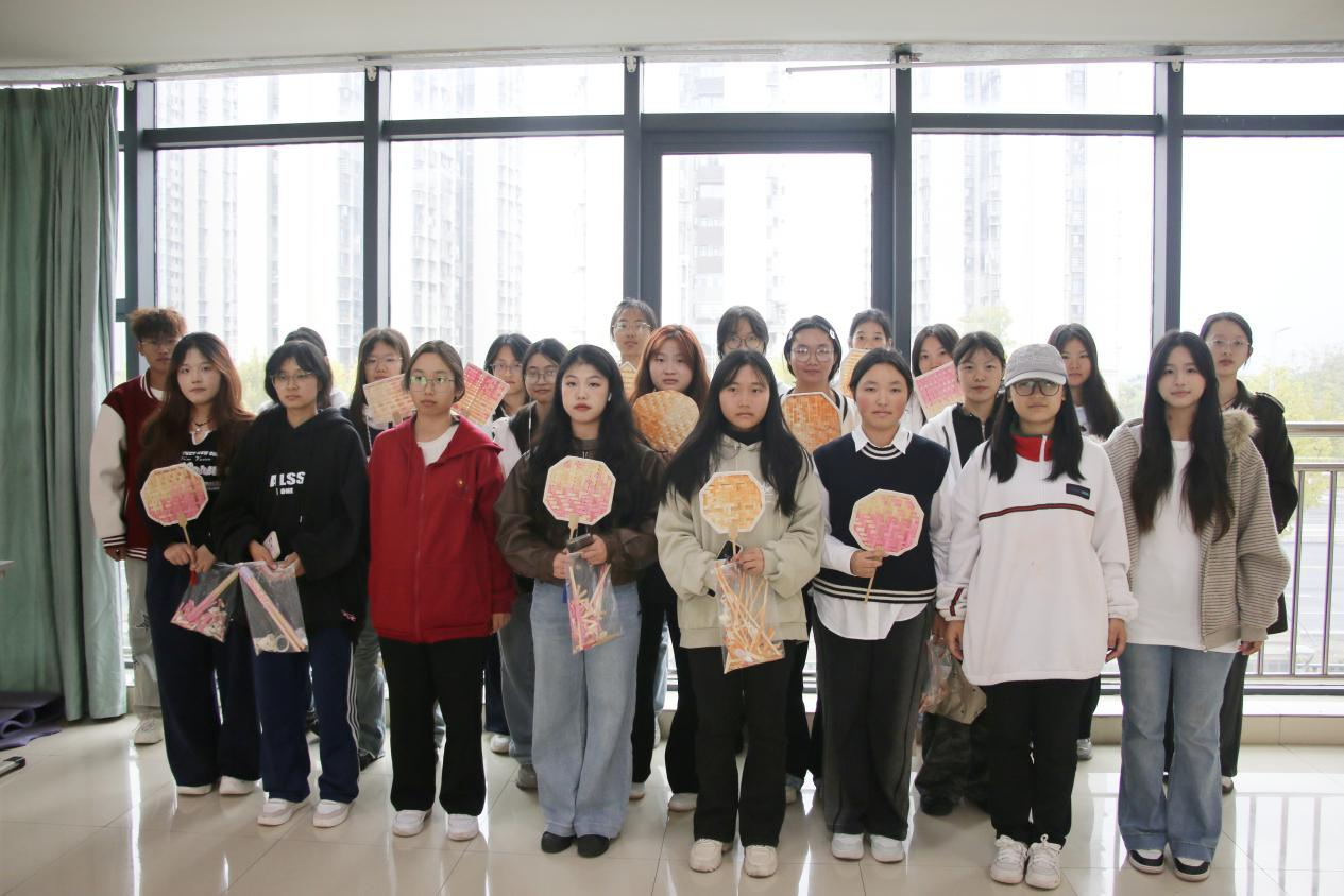 图为学生展示竹编扇DIY作品的合影.png