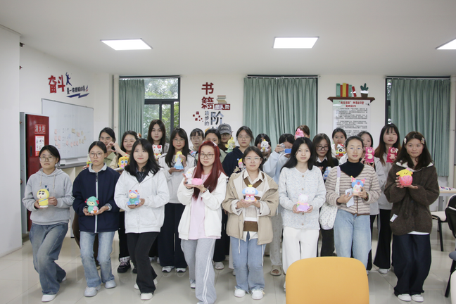 图为学生展示石膏娃娃彩绘作品的合影.png