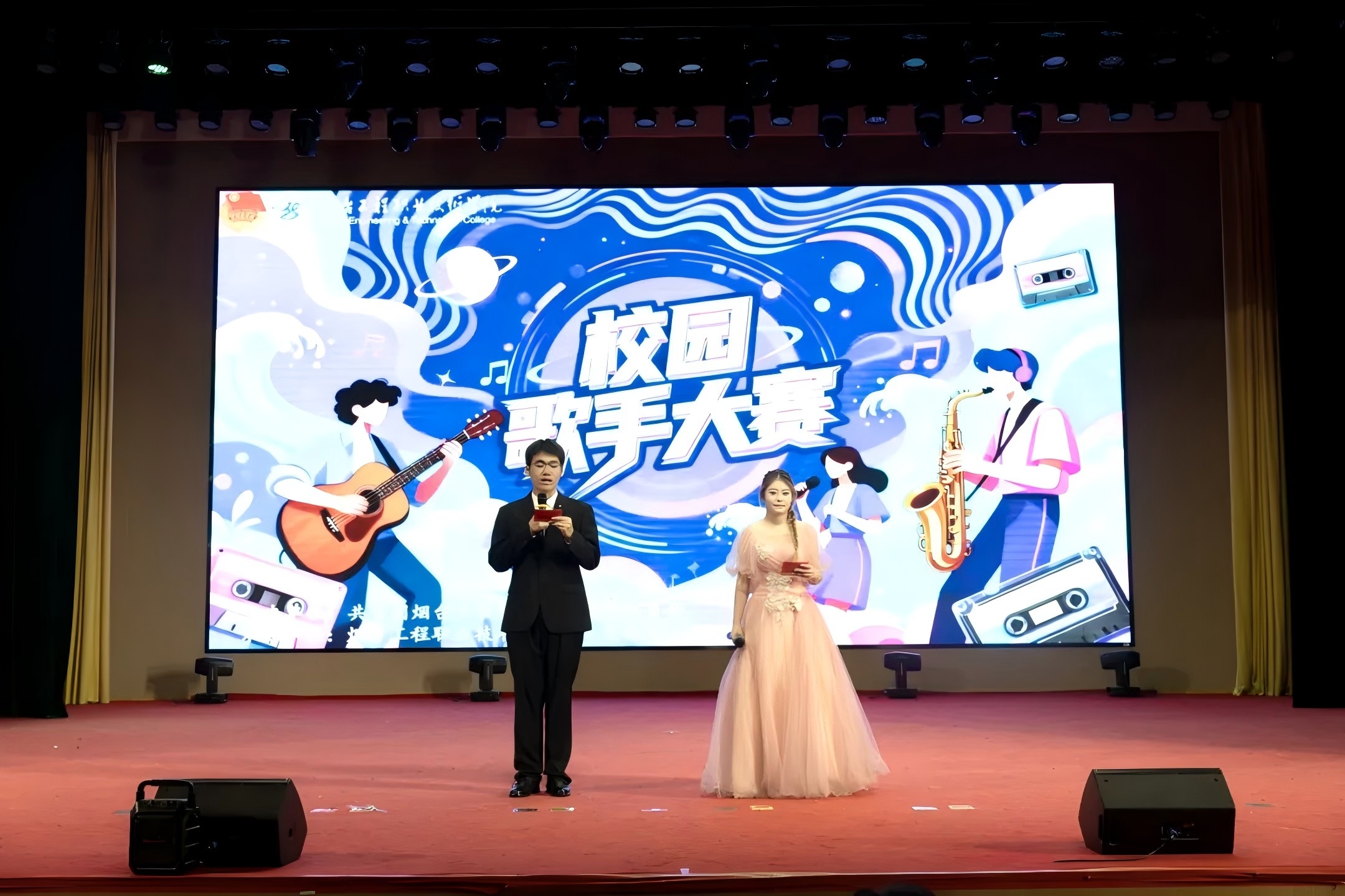 比赛由学院学生处（团委）主办，信息技术系承办。从百余名报名者中脱颖而出的18位选手，带着各自的音乐故事登上舞台。流行、摇滚、民谣、说唱……多元曲风碰撞出无限可能！有人用温柔声线诠释青春心事，有人以高亢嗓音点燃全场热情，更有原创歌手带来惊艳创作，展现烟工学子的艺术才华。一起来回顾大赛的精彩瞬间吧！